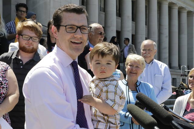 Senator Joe Fain and son, with Senator Karen Keiser and Speaker Frank Chopp to the right, speaking at coalition press conference before Paid Family and Medical Leave bill signing, July 5, 2017.