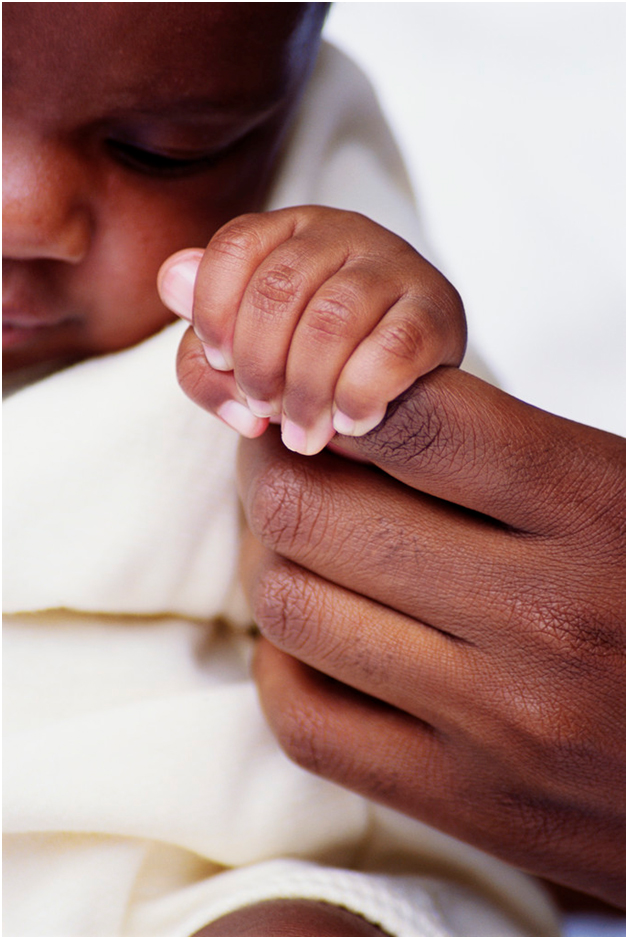 baby holding parent's finger