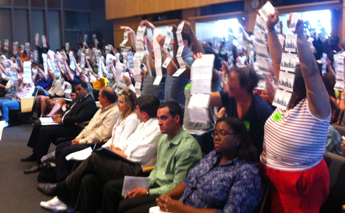Supporters holding postcards signed by thousands of Seattle residents packed the room at City hall to support paid sick days. (Photo: Puget Sound Sage)